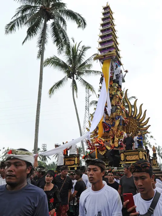 Ribuan warga mengiringi arak-arakan Bade atau menara bertingkat sembilan yang berisi jenazah anggota keluarga dari pahlawan nasional I Gusti Ngurah Rai dalam prosesi upacara Ngaben di Desa Carangsari, Badung, Bali, Senin (29/4/2019). (SONNY TUMBELAKA/AFP)