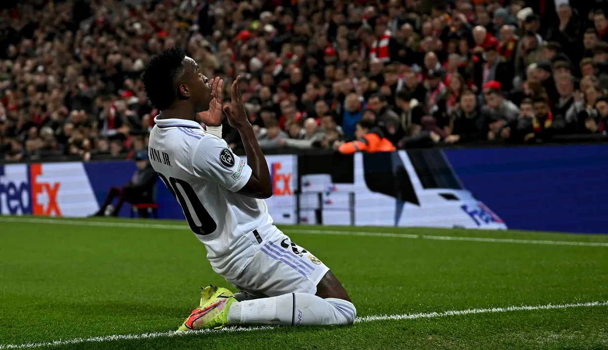 Selebrasi striker Real Madrid, Vinicius Junior setelah mencetak gol ke gawang Liverpool pada leg pertama babak 16 besar Liga Champions 2022/2023 di Anfield Stadium, Liverpool (21/2/2023). Dua gol dicetak Vinicius Junior ke gawang Liverpool di leg pertama babak 16 besar Liga Champions 2022/2023 (21/2/2023). Sementara di leg kedua (15/3/2023) ia gagal menyumbang gol. (AFP/Paul Ellis)