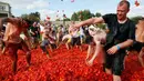 Orang-orang saling melempar tomat ketika berpartisipasi dalam festival 'Tomatina' atau perang tomat di St.Petersburg, Rusia, Minggu (18/8/2019). Tomatina atau perang tomat adalah festival Spanyol, dan tahun ini merupakan pertama kalinya dirayakan di Rusia. (AP Photo/Dmitri Lovetsky)
