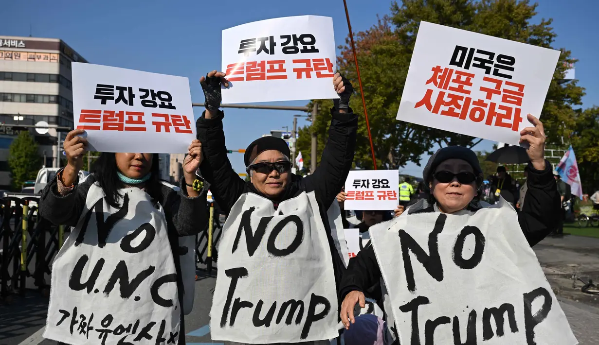 Para demonstran Korea Selatan yang mengenakan spanduk bertuliskan "Tolak Trump" memegang plakat selama demonstrasi yang mengecam tekanan Presiden AS Donald Trump untuk meningkatkan investasi Korea Selatan di AS, di Gyeongju pada 29 Oktober 2025, menjelang KTT Kerja Sama Ekonomi Asia-Pasifik (APEC). (Jung Yeon-je/AFP)
