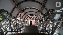 Pejalan kaki menggunakan fasilitas jembatan penyeberangan orang (JPO) di Jalan Kolonel Sugiono, Duren Sawit, Jakarta Timur, Senin (7/2/2022). JPO Kolonel Sugiono yang berada dekat Kanal Banjir Timur itu didesain dengan bentuk yang modern namun sarat kearifan lokal. (merdeka.com/Iqbal S Nugroho)