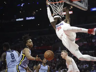 Pemain L. A. Clippers, Willie Reed bergelantungan pada ring usai mencetak poin saat melawan Memphis Grizzlies dalam laga NBA basketball game, di Staples Center, Los Angeles, (2/1/2018). Clippers menang 113-105. (AP/Jae C. Hong)