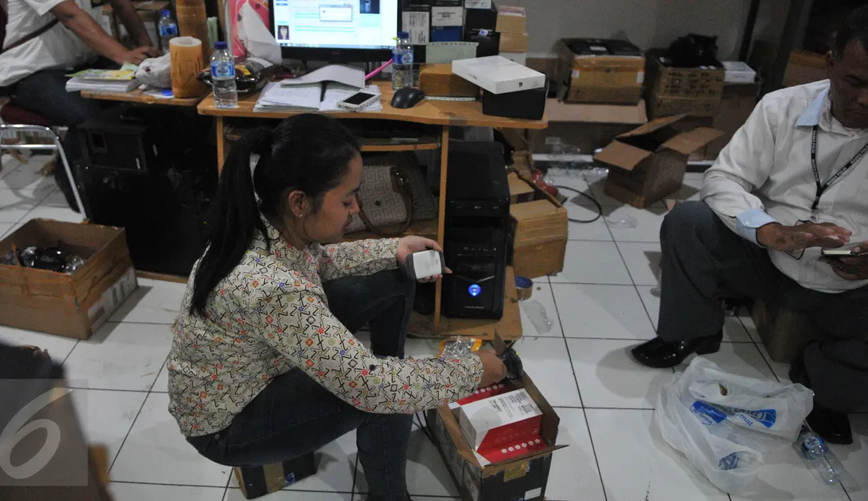 Petugas Bareskrim Polri melakukan penggeledahan dan penyitaan terhadap sejumlah telepon seluler ilegal di gudang distributor, di ruko kawasan Cempaka Mas, Jakarta, Senin(15/6/2015). (Liputan6.com/Herman Zakharia)