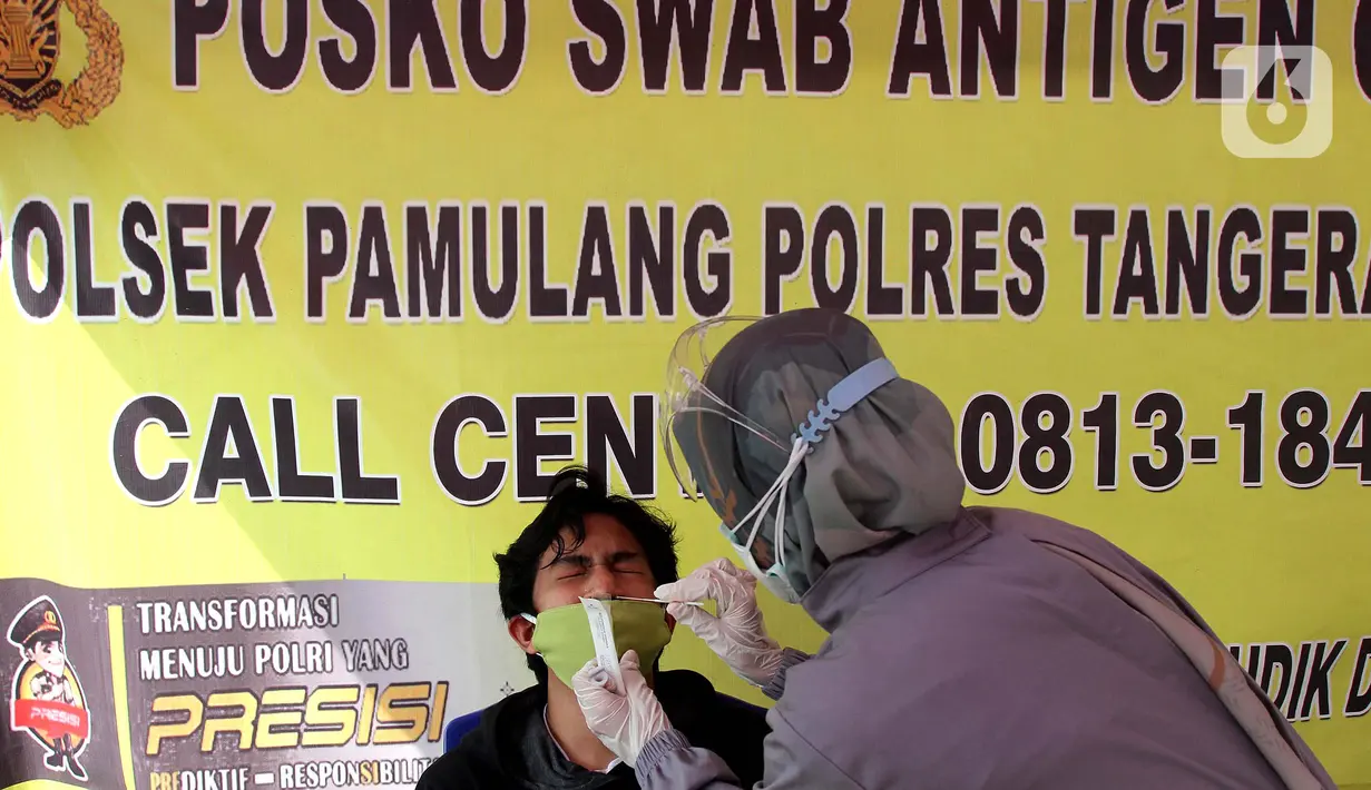 Petugas mengambil sampel lendir hidung untuk pemeriksaan tes swab antigen di Polsek Pamulang, Tangerang Selatan pada Rabu (19/5/2021). Swab antigen gratis itu bagi warga Pamulang yang sudah kembali usai menjalani perjalanan mudik untuk antisipasi penularan virus corona. (merdeka.com/Arie Basuki)
