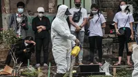 Petugas menyemprotkan disinfektan di area makam pasien Covid-19 di TPU Pondok Kelapa, Jakarta, Selasa (13/7/2021). Tim Koalisi Warga LaporCovid-19 mencatat sebanyak 451 pasien Covid-19 meninggal saat menjalani isolasi mandiri. (merdeka.com/Iqbal S Nugroho)