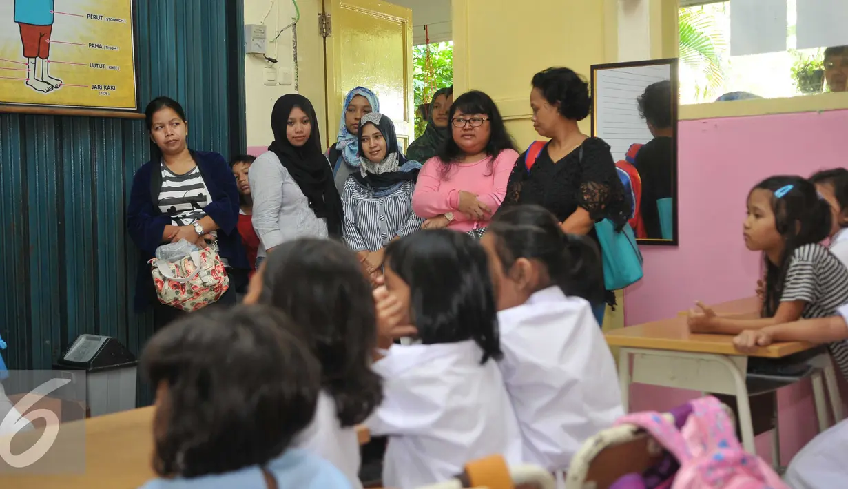 Sejumlah orang tua saat melihat anaknya belajar di hari pertama sekolah di SD Gunung 01, Jakarta, Senin (18/7). Hal ini untuk mencegah tindak kekerasaan dan perploncoan di sekolah pada saat masa orientasi atau pengenalan. (Liputan6.com/Gempur M Surya)
