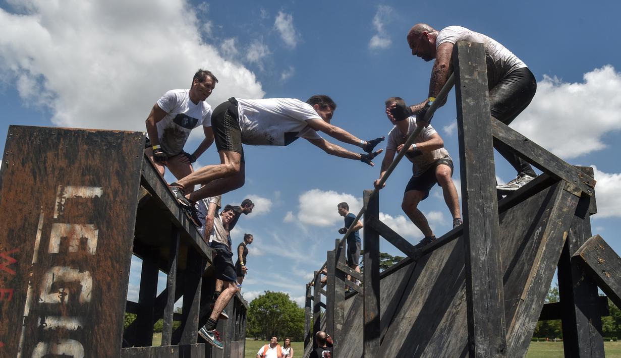 Peserta lomba berusaha melewati rintangan saat mengikuti "Legion Run" di Roma, Italia, Sabtu (13/4). Peserta harus melewati rintangan seperti dari lumpur, es dan kawat berduri dengan jarak tempuh 5 kilometer. (AFP PHOTO / Andreas SOLARO)
