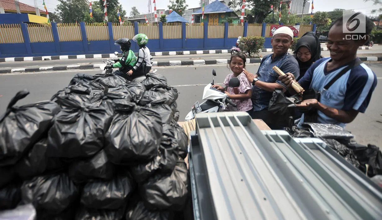 Penjual arang, tusuk sate, dan kotak pemanggang melayani pembeli di kawasan Manggarai, Jakarta, Rabu (22/8). Penjual mengaku meraup untung hingga Rp 1 juta dalam satu minggu menjual perlengkapan membuat sate. (Merdeka.com/Iqbal Nugroho)