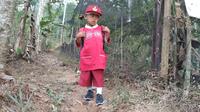 Jodi bocah pemungut cengkeh asal Kuningan Jawa Barat memiliki semangat bersekolah meski harus naik turun bukit menuju sekolah. Foto (Liputan6,com / Panji Prayitno)