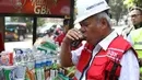 Menteri PUPR, Basuki Hadimuljono menikmati kopi yang dijajakan pedagang seusai meninjau renovasi stadion di Gelora Bung Karno (GBK), Jakarta, Kamis (10/5). Basuki meninjau kesiapan fasilitas dan prasarana untuk Asian Games 2018 (Liputan6.com/Angga Yuniar)