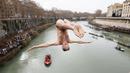 Marco Fois menyelam ke dalam Sungai Tiber untuk merayakan tahun baru 2024 di Roma, Italia, Senin (1/1/2024). (AP Photo/Domenico Stinellis)