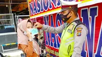 Polisi membagikan masker kepada warga untuk meminimalisir penyebaran Covid-19 di Riau. (Liputan6.com/M Syukur)