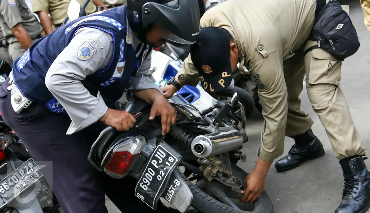 Petugas Kelurahan Senen bersama Dishub DKI dan Satpol PP menggelar razia parkir liar di wilayah Senen, Jakarta Pusat, Selasa (29/3/2016). Kendaraan roda dua terparkir di bahu jalan ataupun trotoar langsung dicabut pentil. (Liputan6.com/Yoppy Renato)