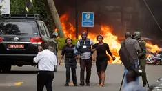 Pasukan keamanan membantu warga melarikan diri dari lokasi penyerangan sebuah kompleks hotel mewah di Nairobi, Kenya, Selasa (15/1). Dilansir dari CNN, 15 orang dinyatakan tewas dalam serangan tersebut. (AP Photo/Ben Curtis)