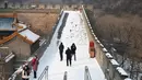Sejumlah wisatawan saat menikmati liburan musim dingin di Tembok Besar China yang diselimuti salju di utara Beijing (6/1/2020). (AFP/Greg Baker)