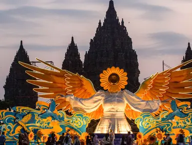 Orang-orang berkumpul di depan "Sunflower Angel", instalasi seni fiberglass setinggi sembilan meter karya seniman lokal Arrofi Ramadhan, di Candi Prambanan, kompleks candi Hindu abad ke-9 yang terdaftar sebagai Situs Warisan Dunia UNESCO, Sleman, Yogyakarta, pada Sabtu 6 Juni 2026. (DEVI RAHMAN/AFP)