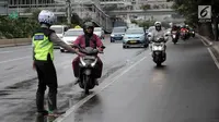 Polisi memberhentikan pengendara motor yang melanggar aturan jalur khusus di Jalan MH Thamrin, Jakarta Pusat, Kamis (8/2). Sosialisasi jalur khusus sepeda motor ini telah dilakukan polisi pada 29 Januari - 4 Febuari 2018 lalu. (Liputan6.com/Arya Manggala)