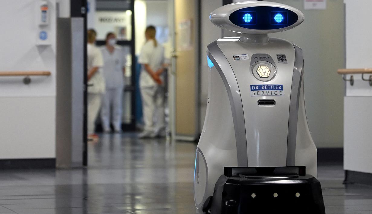 Robot pembersih 'Franzi' membersihkan area pintu masuk rumah sakit di Munich Neuperlach, Jerman selatan pada 12 Februari 2021. Di masa pandemi COVID-19, robot pembersih Franzi telah mempunyai peran baru, yaitu menghibur staf dan pasien di rumah sakit Munich. (Photo by Christof STACHE / AFP)