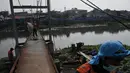 Sejumlah pekerja sedang memperbaiki jembatan gantung yang rusak di aliran Kanal Banjir Barat (KBB), Jakarta, (1/9/14). (Liputan6.com/Johan Tallo)