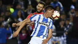 Bek Real Madrid, Nacho Fernandez, duel udara dengan striker Leganes, Guido Carrillo, pada laga La Liga di Stadion Municipal Butarque, Senin (15/4). Kedua tim bermain imbang 1-1. (AFP/Pierre Philippe Marcou)