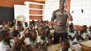 Didier Drogba bercengkrama dengan anak-anak sekolah saat pembukaan sekolah dasar di Onahio, Pokou-Kouamekro, Pantai Gading, (20/1/2018).  Drogba menjadi salah satu sponsor utama untuk sekolah tersebut. (AFP/Sia Kambou)