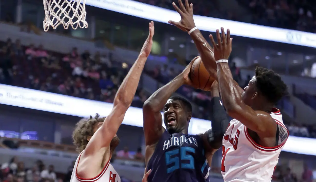 Pemain Charlotte Hornets, Roy Hibbert #55 berusaha melewati dua pemain Chicago Bulls, Robin Lopez (kiri) dan Jimmy Butler pada laga NBA preseason basketball game di Chicago, Selasa (18/10/2016) WIB.  (AP/Charles Rex Arbogast)