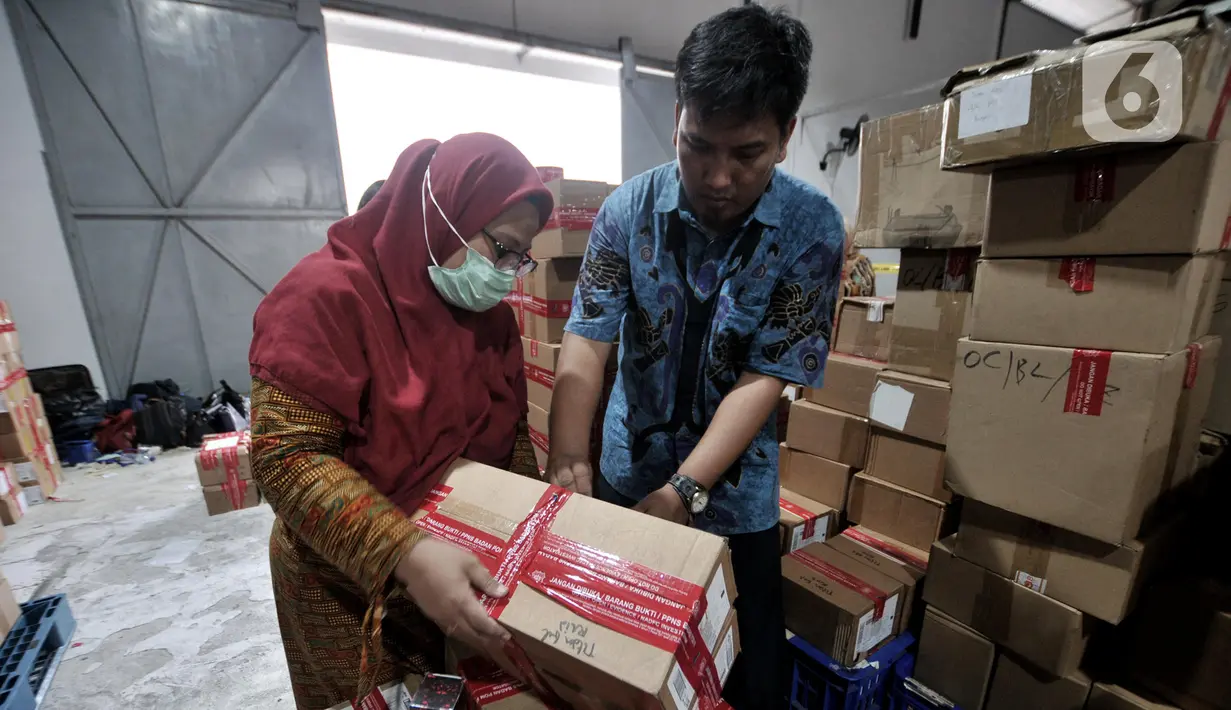 Petugas PPNS BPOM memeriksa barang bukti hasil pengungkapan kasus peredaran obat dan makanan ilegal di sebuah gudang kawasan Sunter, Jakarta, Selasa (10/12/2019). BPOM membongkar jaringan peredaran kosmetik, obat tradisional, dan pangan olahan ilegal. (merdeka.com/Iqbal Nugroho)