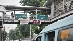 Warga melintasi spanduk dukungan Persija yang terpasang di JPO, Jakarta, Minggu (9/12).  Dalam spanduk tersebut bertuliskan berbagai ungkapan dukungan dan doa para The Jakmania agar Persija menjadi juara Liga 1 2018. (Merdeka.com/Iqbal S. Nugroho)