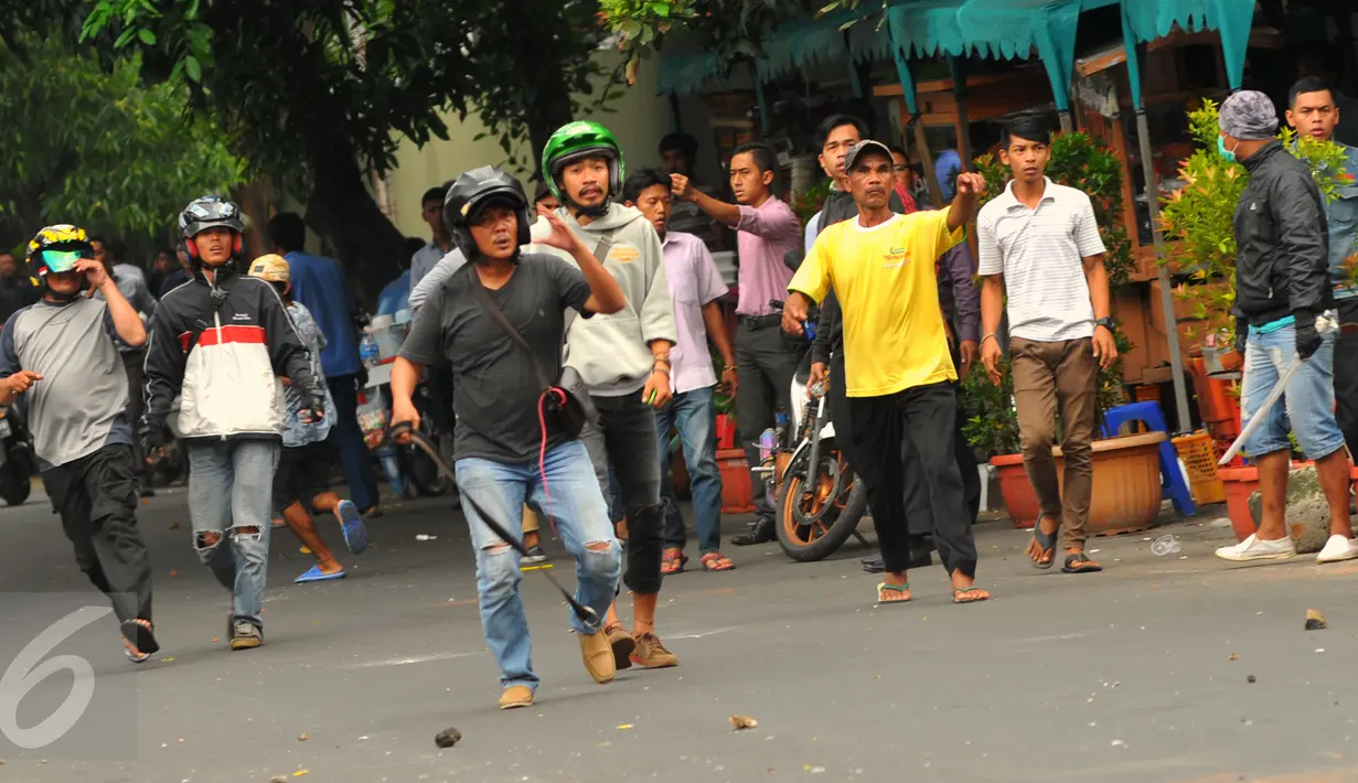 Pengemudi taksi yang berunjuk rasa di kawasan Sudirman terlibat tawuran dan aksi lempar batu dengan pengemudi ojek online, Jakarta, Selasa (22/3). Aksi itu pecah saat pengunjuk rasa mendapat perlawan dari pengemudi ojek online (Liputan6.com/Faisal R Syam)