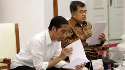 Presiden Joko Widodo dan Wakil Presiden Jusuf Kalla melihat berkas sebelum rapat bersama kabinet kerja di Istana Bogor, Jawa Barat, Senin (16/2/2015). (Liputan6.com/Faizal Fanani)