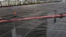 Petugas PPSU membersihkan sampah yang tertutup jaring hitam di Kali Item, Kemayoran, Jakarta, Jumat (20/7). Pemasangan jaring dilakukan untuk menutupi keruhnya air dan bau tak sedap di Kali Item. (Liputan6.com/Arya Manggala)