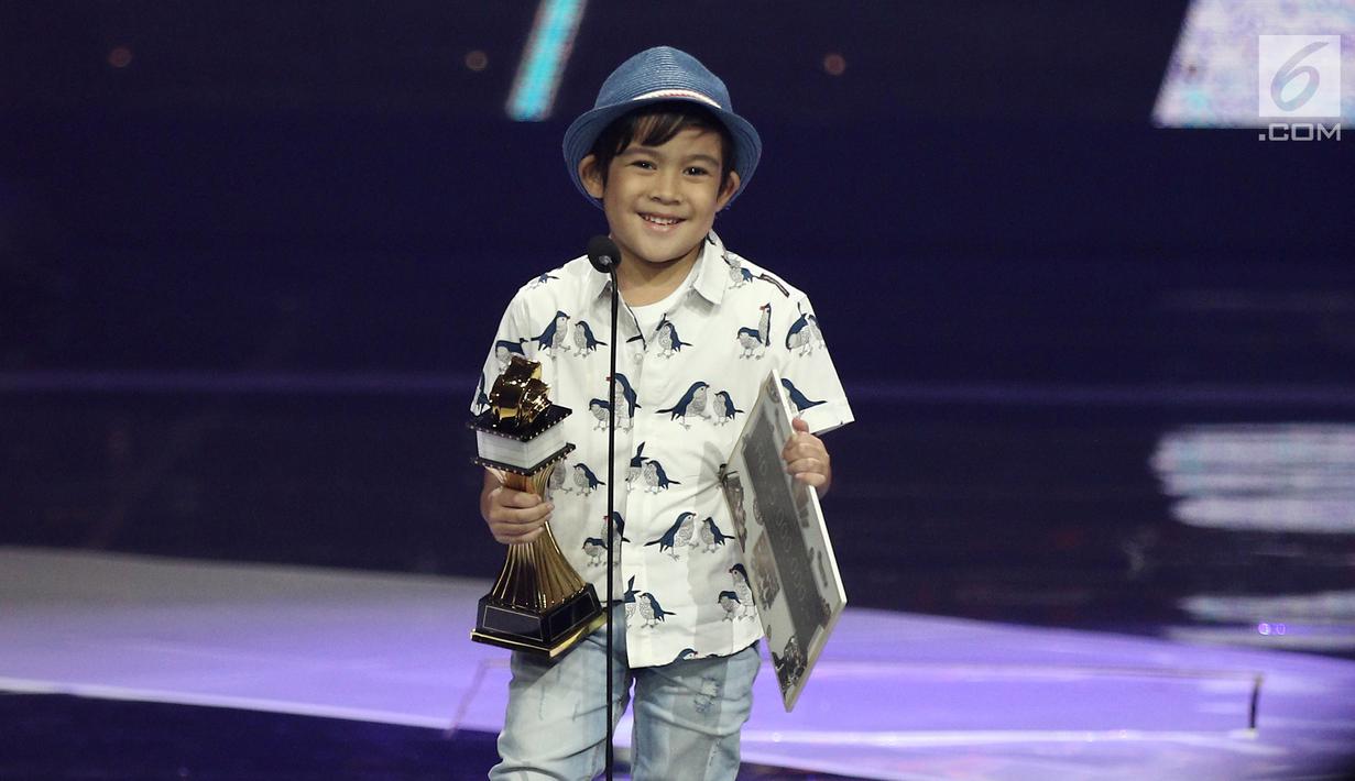 Aktor Muhammad Adhiyat saat menerima penghargaan dalam acara IBOMA 2018 di STUDIO 6 EMTEK CITY, Jakarta, Jumat (23/3/2018). Adhiyat berhasil menyabet penghargaan pada kategori pendatang baru terbaik. (Liputan6.com/Herman Zakharia)