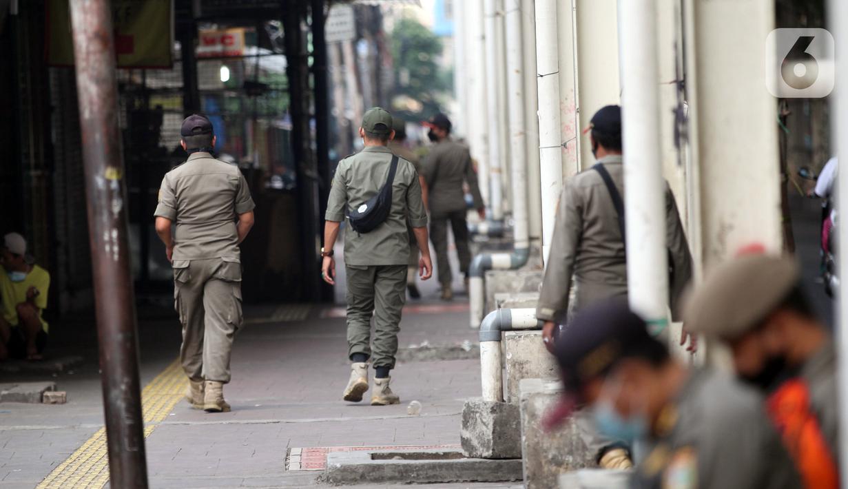 Petugas Satpop PP berpatroli di kawasan Pasar Tanah Abang, Jakarta, Rabu (7/7/2021). Satpol PP melakukan penjagaan di seluruh Pasar Tanah Abang mengantisipasi pedagang yang membandel tetap berjualan saat diberlakukannya PPKM Darurat. (Liputan6.com/Angga Yuniar)