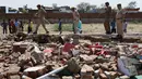 Polisi India melakukan olah lokasi ambruknya sebuah tembok bangunan yang dijadikan pesta pernikahan di Rajashtan, India, Kamis (11/5). Musibah terjadi saat sebuah dinding yang berada di sekitar lokasi pesta runtuh setelah dihantam badai (MONEY SHARMA/AFP)
