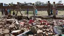 Polisi India melakukan olah lokasi ambruknya sebuah tembok bangunan yang dijadikan pesta pernikahan di Rajashtan, India, Kamis (11/5). Musibah terjadi saat sebuah dinding yang berada di sekitar lokasi pesta runtuh setelah dihantam badai (MONEY SHARMA/AFP)