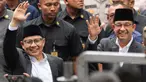 Calon presiden dengan nomor urut 1 Anies Baswedan (kanan) bersama Calon Wakil Presiden Muhaimin Iskandar melambaikan tangan saat tiba untuk menghadiri "Deklarasi Kampanye Pemilu Damai" di Gedung Komisi Pemilihan Umum (KPU), Jakarta, Senin, 27 November 2023. (AP Photo/Tatan Syuflana)