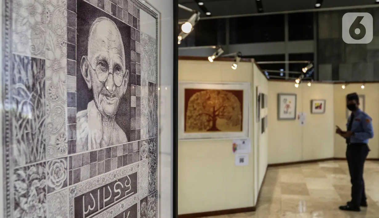 Pengamanan dalam DPR  melihat karya lukis dan karya foto pada pameran 150 Tahun Mahatma Gandhi di kompleks Parlemen, Senayan, Jakarta, Jumat (2/10/2020). Dalam pameran ini juga memperingati 150 tahun hari kelahiran Mahatma Gandhi serta Peringatan Hari Anti Kekerasan Dunia. (Liputan6.com/Johan Tallo)