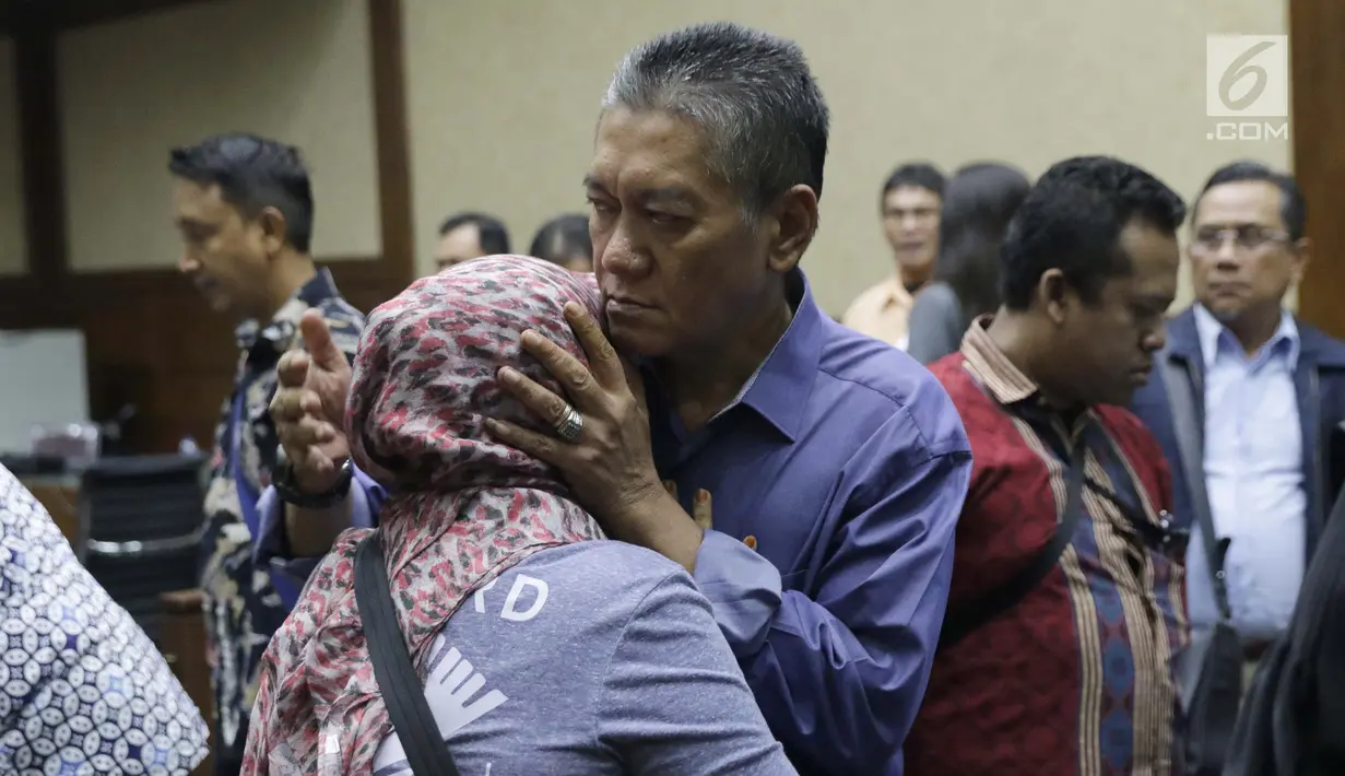 Terdakwa suap putusan perkara perdata yang juga Hakim PN Jakarta Selatan, Irwan memeluk kerabatnya usai sidang pembacaan tuntutan di Pengadilan Tipikor, Jakarta, Kamis (13/4/2019). Irwan dan Iswahyu Widodo diyakini bersalah menerima uang Rp 150 juta dan SGD 47 ribu. (Liputan6.com/Helmi Fithriansyah)