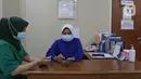 Tenaga kesehatan mengecek pesan singkat penerima vaksin COVID-19 di RSIA Tambak, Jakarta, Selasa (5/01/2021). Kementerian Kesehatan mengirimkan Short Message Service (SMS) blast secara serentak kepada penerima vaksin COVID-19 tahap pertama pada Kamis (31/12) lalu. (Liputan6.com/Herman Zakharia)