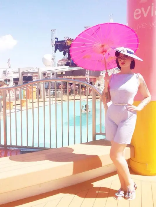 Tampilan kece Claudia mengenakan sleeveless dress dan fascinator warna senada. (Instagram/miss_adinda_mae).