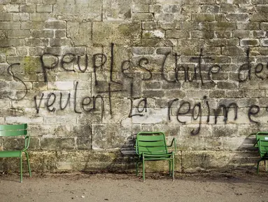 Grafiti bertuliskan 'rakyat menginginkan jatuhnya sistem' tertulis pada dinding di Kebun Tuileries, Paris, Prancis, Minggu (2/12). Protes atas kenaikan pajak bahan bakar telah tumbuh menjadi kemarahan umum. (AP Photo/Kamil Zihnioglu)