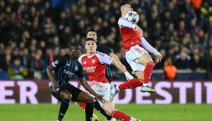 Penyerang Arsenal asal Brasil bernomor punggung 11, Gabriel Martinelli (kanan), mengontrol bola di udara selama pertandingan Liga Champions UEFA, Phase League - pekan ke-6, antara Club Brugge dan Arsenal di stadion Jan Breydel di Bruges, Kamis (11-12-2025) dini hari WIB. (NICOLAS TUCAT/AFP)