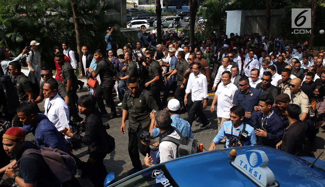 Presiden terpilih Joko Widodo atau Jokowi bersama Ketua Umum Partai Gerindra Prabowo Subianto saat tiba di Stasiun MRT Senayan, Jakarta, Sabtu (13/7/2019). Jokowi dan Prabowo terlihat mendapat pengawalan ketat aparat. (Liputan6.com/JohanTallo)