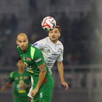 Pemain Persebaya, Risto Mitrevski berduel dengan pemain PSIM Yogyakarta, Nermin Haljeta pada pertandingan pembuka BRI Super League 2025/2026 di Stadion Gelora Bung Tomo, Jumat (08/08/2025) malam WIB. (Bola.com/Abdul Aziz)
