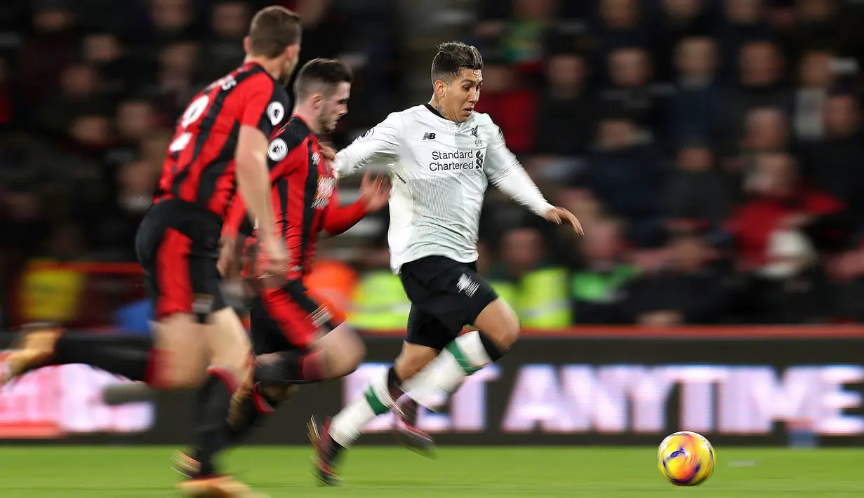 Gelandang Liverpool, Roberto Firmino menendang bola dengan kawalan pemain AFC Bournemouth pada pekan 18 Premier League di Vitality Stadium, Minggu (17/12). Liverpool mencukur tuan rumah AFC Bournemouth empat gol tanpa balas. (Andrew Matthews/PA via AP)