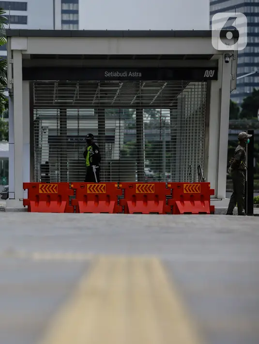 Petugas berjaga di pintu masuk Stasiun MRT Setiabudi yang tutup, Jakarta, Senin (27/4/2020). PT MRT Jakarta menutup dua stasiun MRT yang merupakan lanjutan dari penutupan lima stasiun sebelumnya guna mendukung penerapan Pembatasan Sosial Berskala Besar (PSBB) Jakarta. (Liputan6.com/Faizal Fanani)