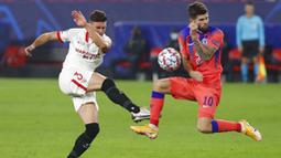 Gelandang Chelsea, Christian Pulisic, berusaha menghadang tendangan pemain Sevilla, Sergi Gomez, pada laga Liga Champions di Stadion Ramon Sanchez Pijuan, Kamis (3/12/2020). Chelsea Menang dengan skor 4-0. (AP/Angel Fernandez)