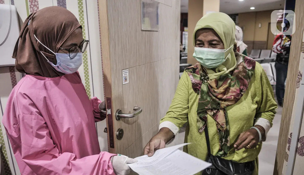 Salah seorang warga lansia menunjukkan bukti kesehatan sebelum mengikuti vaksin Covid-19 di Puskesmas Kecamatan Cilincing, Jakarta, Selasa (23/2/2021). Puskesmas Kecamatan Cilincing akan menggelar vaksinasi bagi lansia hingga Jumat (26/2) dengan kuota 100 orang per hari. (merdeka.com/Iqbal S. Nugroh