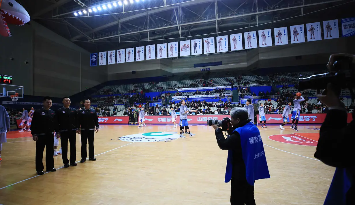 Fotografer Hong Nanli mengambil gambar selama pertandingan bola basket di Shanghai, China (16/1). Nenek Hong Nanli sendiri bertubuh mungil dengan tinggi 153 cm, dan berusia 79 tahun. (AFP Photo/China Out)