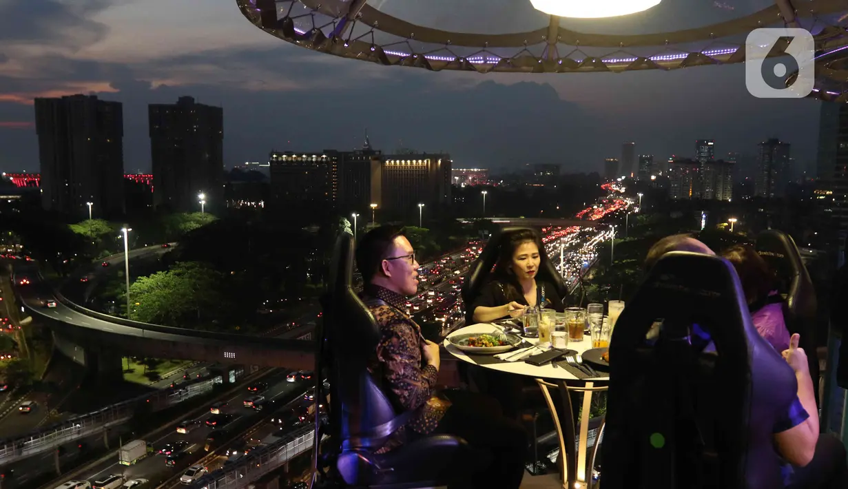 Pengunjung menyantap hidangan di Lounge in the sky, Jakarta, Selasa (29/3/2022). Lounge in the sky merupakan restoran dengan menyajikan sensasi menyantap hidangan dari atas ketinggian dengan pemandangan cakrawala 360 derajat Jakarta. (Liputan6.com/Herman Zakharia)